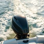 Electric outboard motor on a boat in calm water.