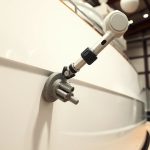 Robot arm sanding boat hull.