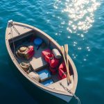 Small boat with essential gear floating on water.