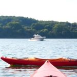 People enjoying various boating activities on calm water.