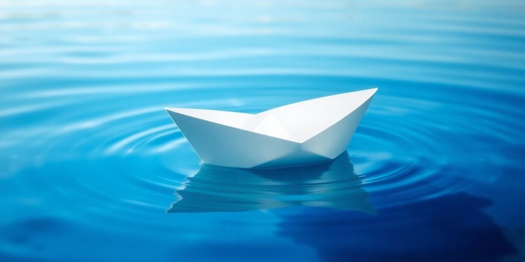 Paper boat floating on clear water, close-up.
