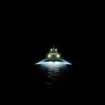 Boat navigating dark water at night