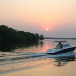 Boat on calm Florida water at sunset.
