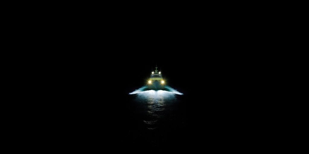 Boat navigating dark water at night