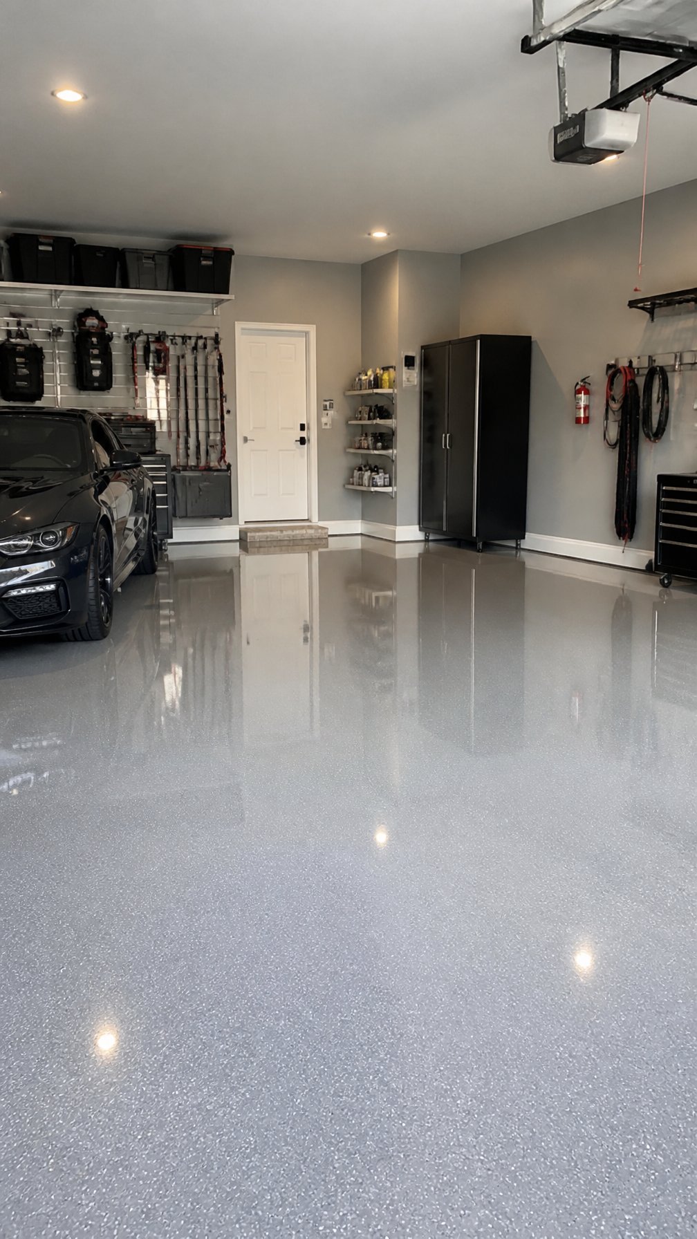 A clean garage interior with a smooth, glossy coated floor and organized storage shelves.